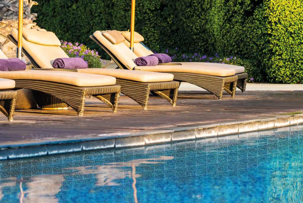 Beautiful outdoor swimming pool with bed deck chair and umbrella